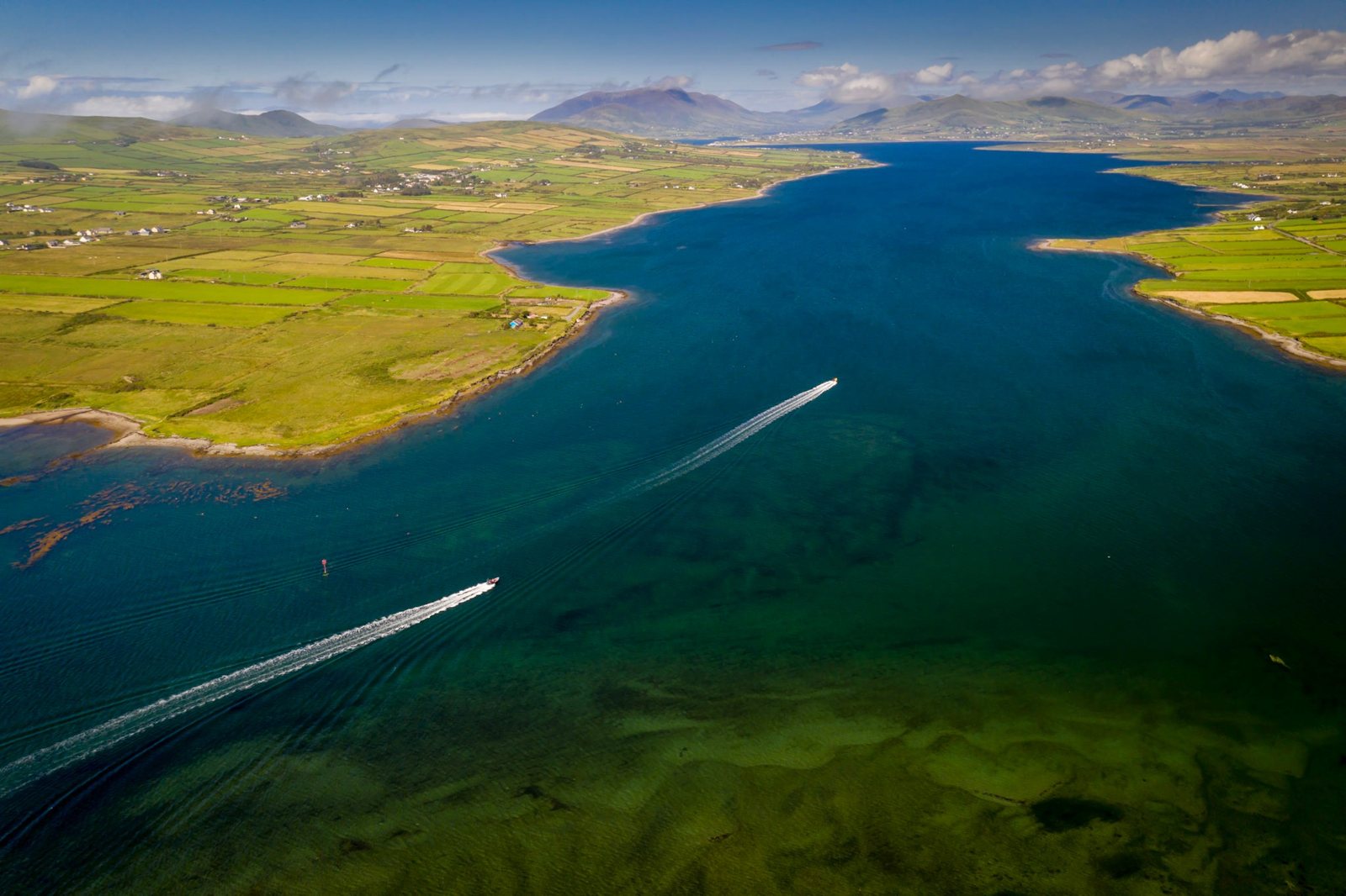 Aerial view of boats speeding up the Portmagee channel towards the Kerry mountains