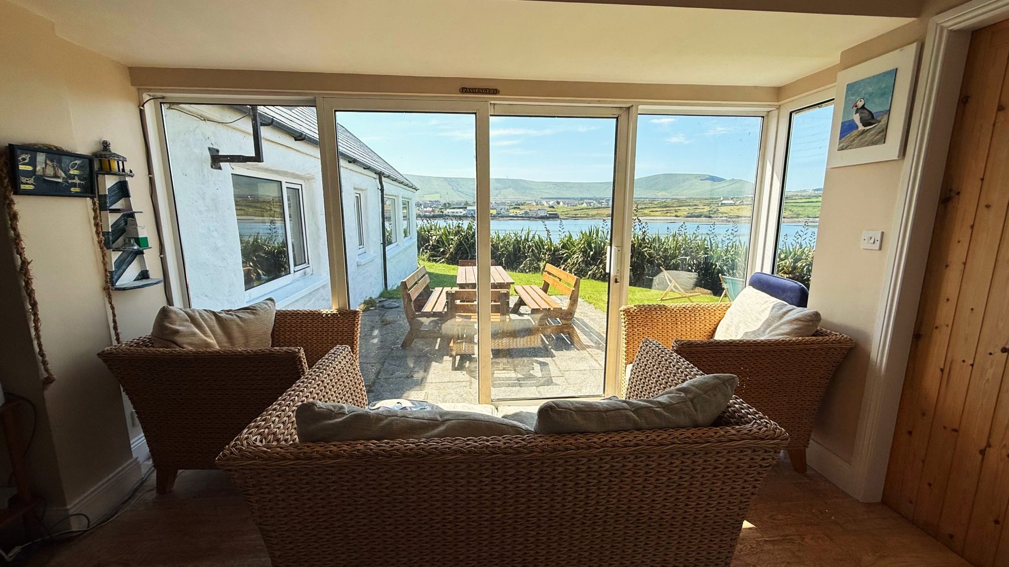 Sunroom with wicker chairs opening onto a terrace and picnic table